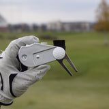 En närbild när en person med golfhandske håller i en 5 in 1 Club Cleaner.