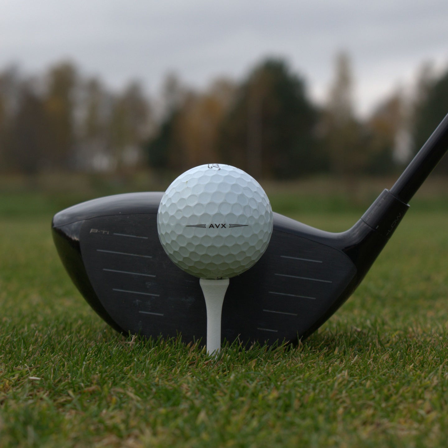 Närbild på Titleist AVX som ligger upp peggad framför en driver.