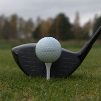 Närbild på Titleist AVX som ligger upp peggad framför en driver.