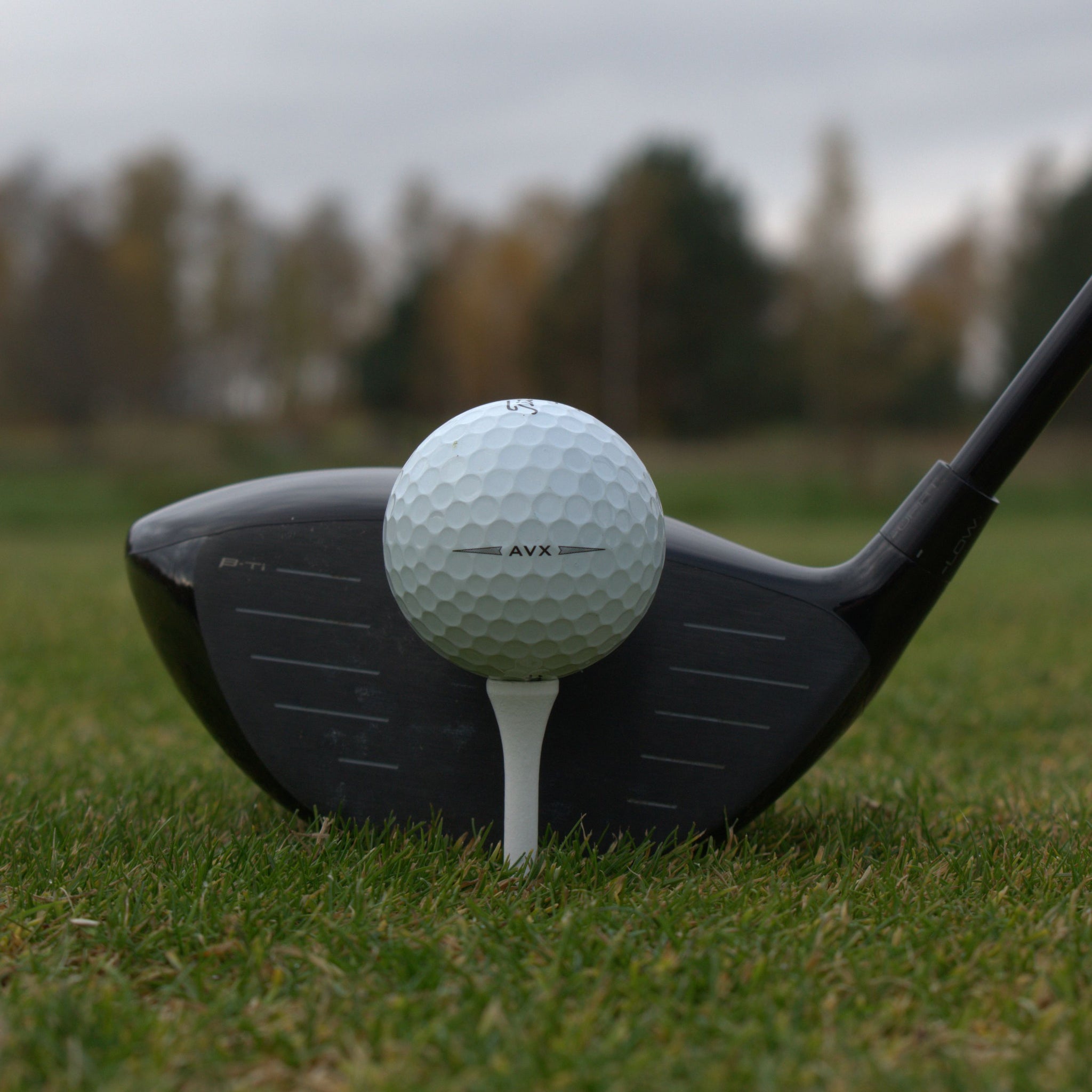 Närbild på Titleist AVX som ligger upp peggad framför en driver.