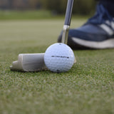 En närbild på en Wilson DX2-Soft golfboll som ligger på en green framför en golf putter.