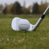 En närbild på Wilson Staff Professional golfboll som ligger lite upp peggad framför en golfklubba.