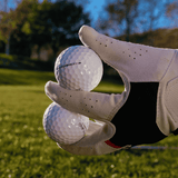 Kirkland Performance+ golfbollar som hålls av en golfare med golfhandske, hållbart och prisvärt val för golfare