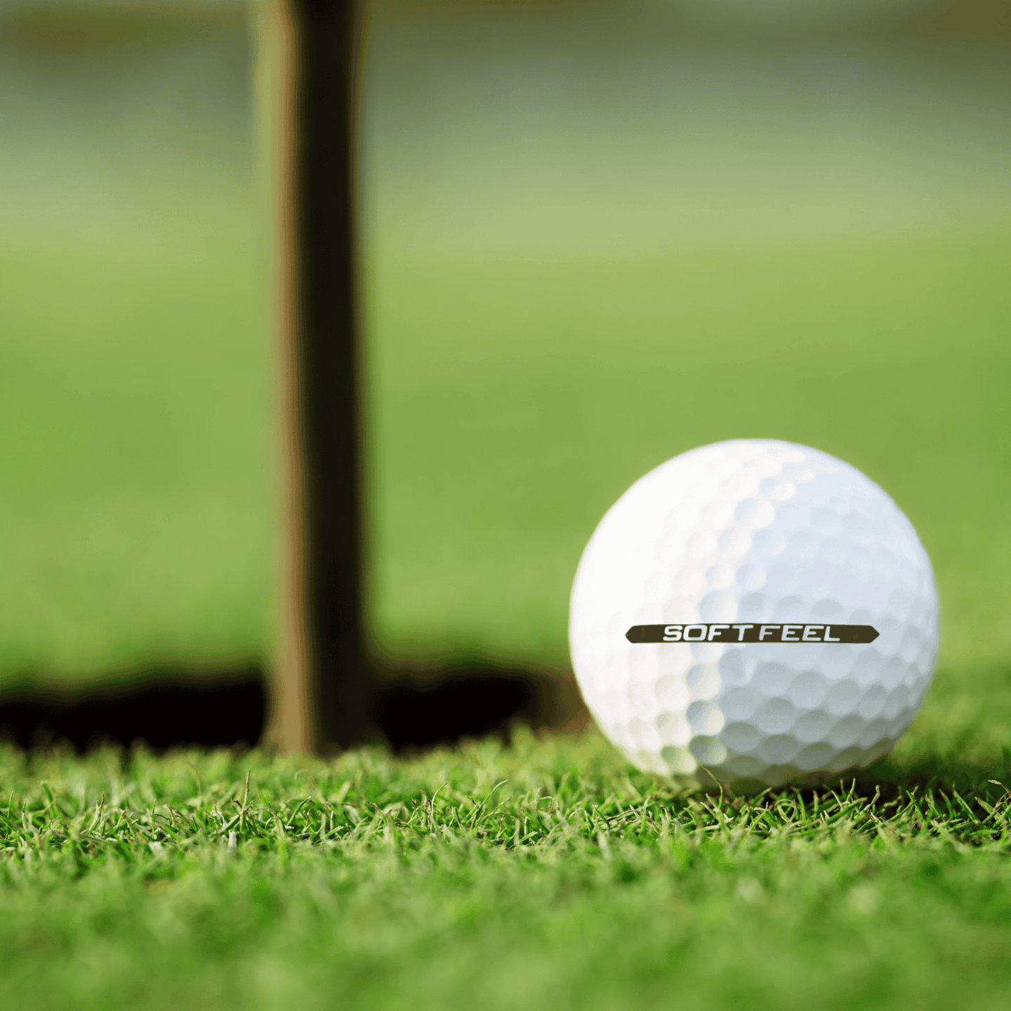 Srixon Soft Feel golfbollar 12-pack på gräs vid en golfhålskopp