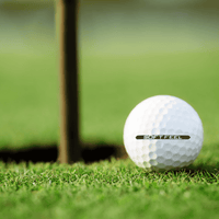 Srixon Soft Feel golfbollar 12-pack på gräs vid en golfhålskopp