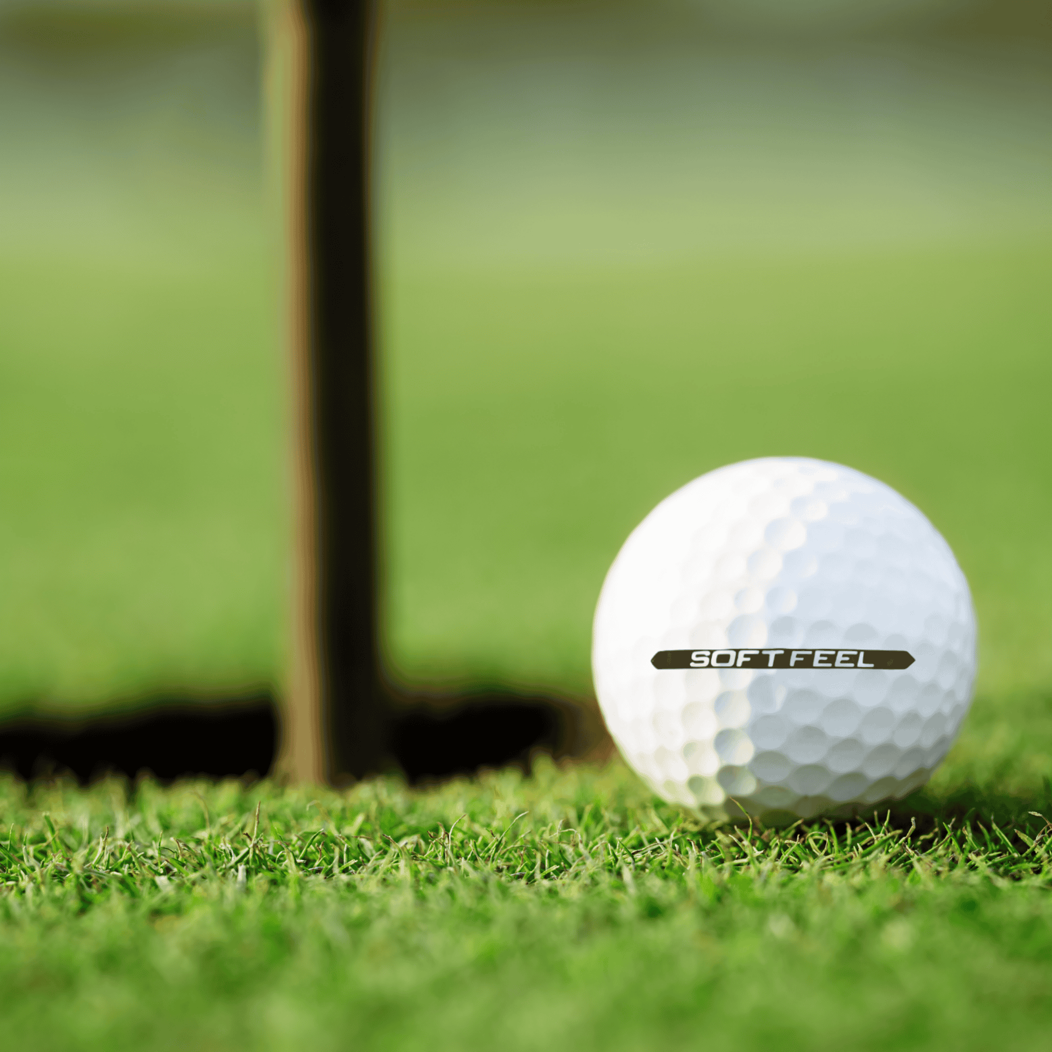 Srixon Soft Feel golfbollar 12-pack på gräs vid en golfhålskopp