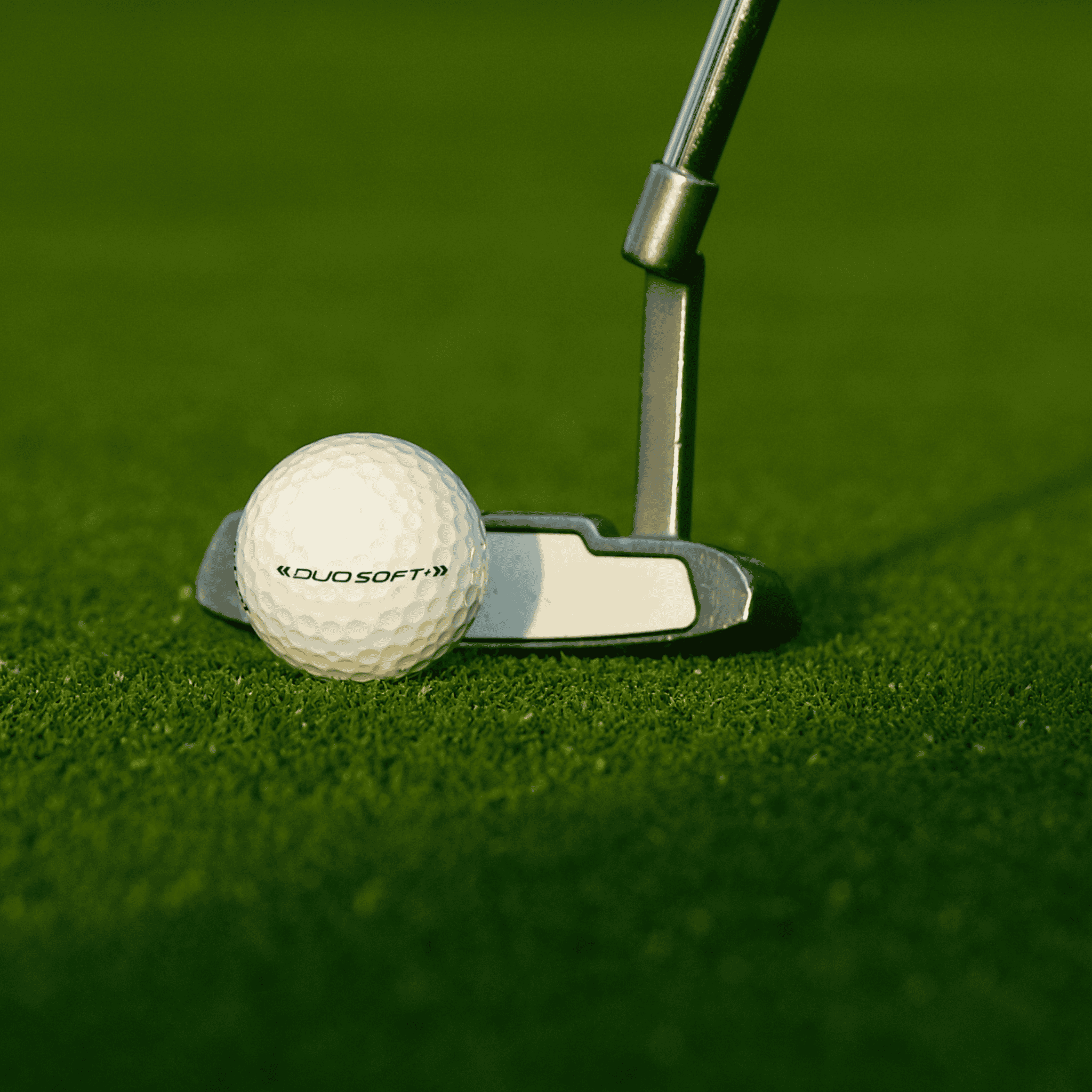 Wilson Duo Soft golfbollar 12-pack på gräs framför en putter